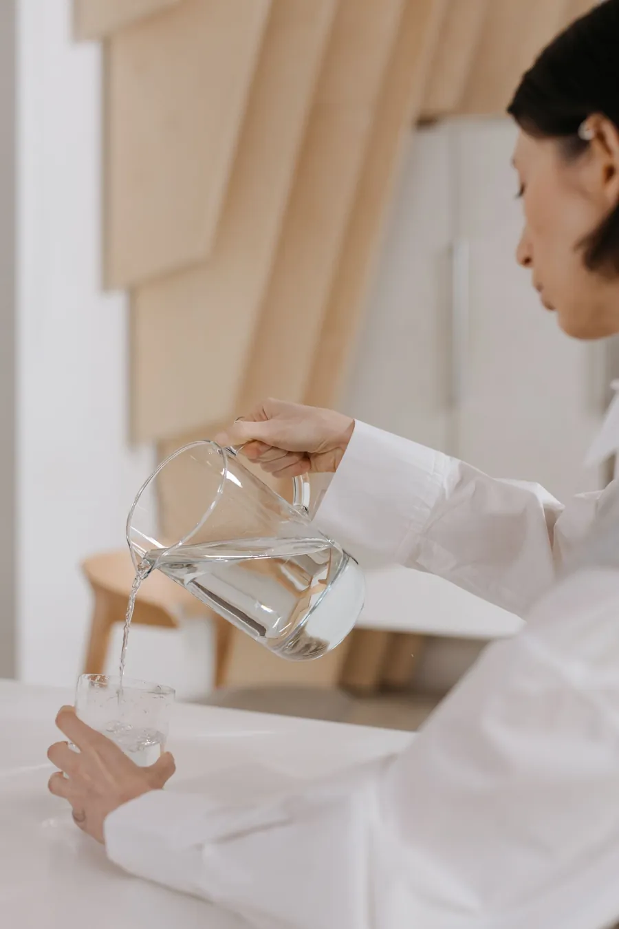 Pouring water from a pitcher, like topping up a water-cooled mattress pad