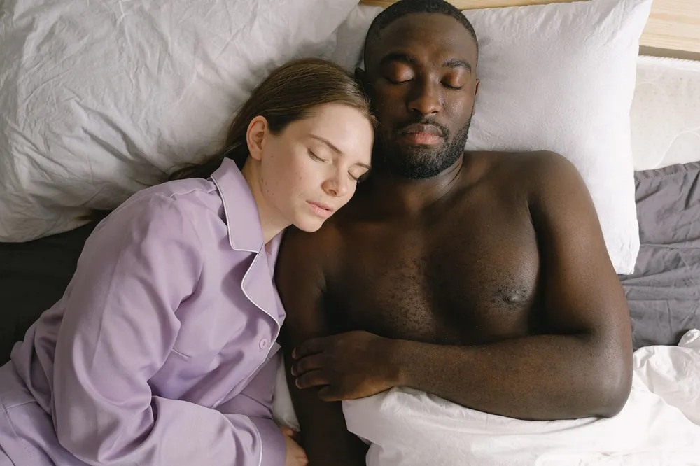Couple sleeping in a king bed, sizing a dual-zone water-cooled mattress pad